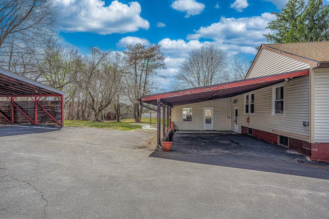 view of vehicle parking with aphalt driveway and a carport