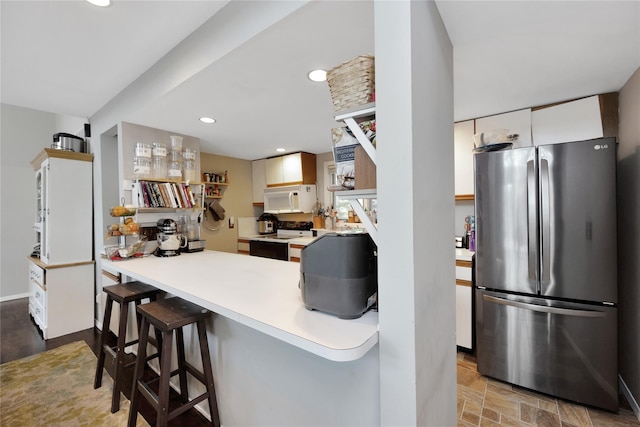 18 Warner Ct, Baiting Hollow, NY 11933 - kitchen featuring light countertops, freestanding refrigerator, electric stove, white microwave, and white cabinetry