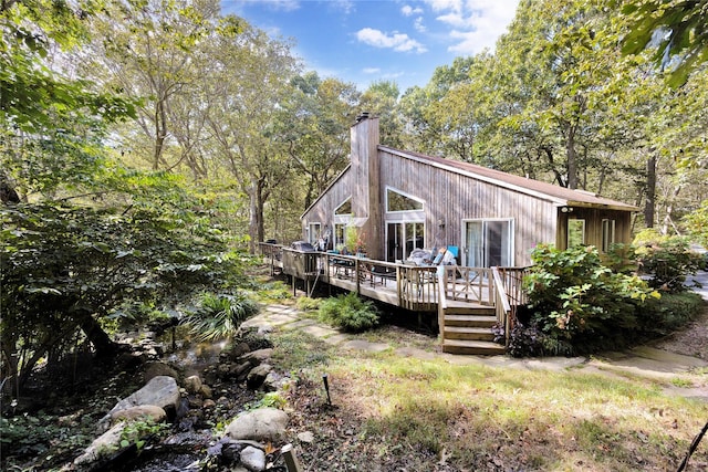 18 Warner Ct, Baiting Hollow, NY 11933 - rear view of house with a forest view, a wooden deck, and a chimney