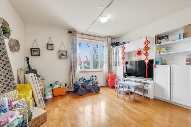 recreation room with light wood-style flooring