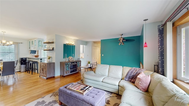 living room with light wood-type flooring and a notable chandelier