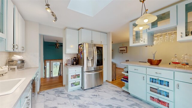 kitchen with light countertops, white cabinetry, appliances with stainless steel finishes, and decorative backsplash