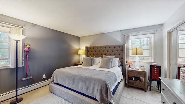bedroom featuring multiple windows and baseboard heating
