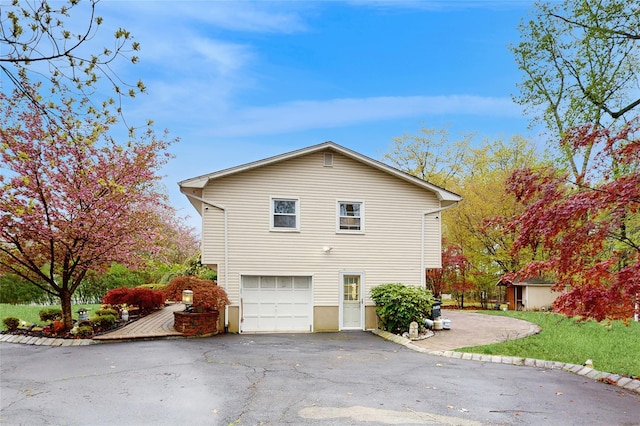 view of side of property featuring driveway and a garage