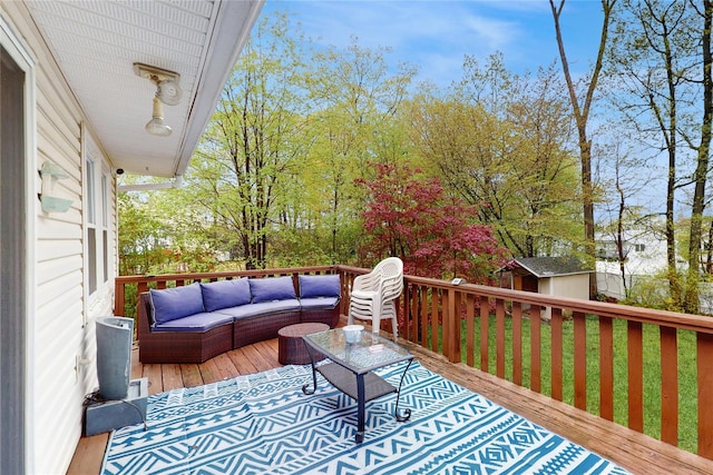 wooden terrace with outdoor lounge area, an outdoor structure, and a shed