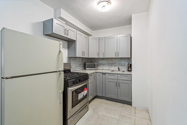89-15 Parsons Blvd Unit 3J, Jamaica, NY 11432 - kitchen featuring freestanding refrigerator, stainless steel gas range, light countertops, gray cabinetry, and backsplash