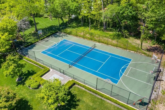 view of tennis court with community basketball court and fence