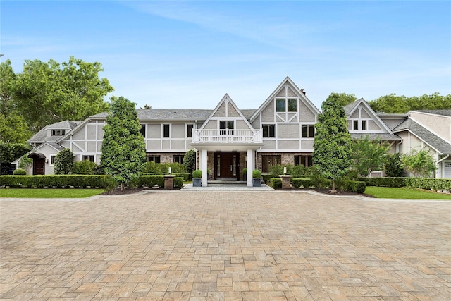 view of front of house featuring driveway, stucco siding, and a balcony
