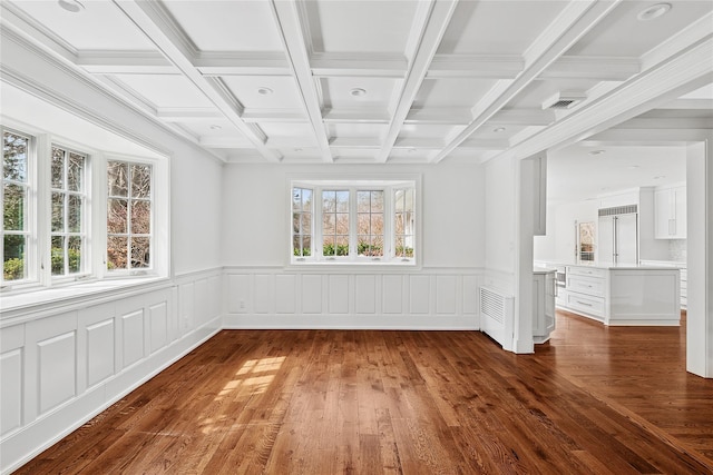 spare room featuring beamed ceiling, a wainscoted wall, coffered ceiling, and wood finished floors