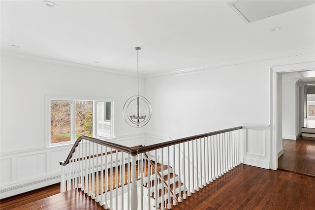 staircase featuring wood finished floors, ornamental molding, visible vents, and a wainscoted wall