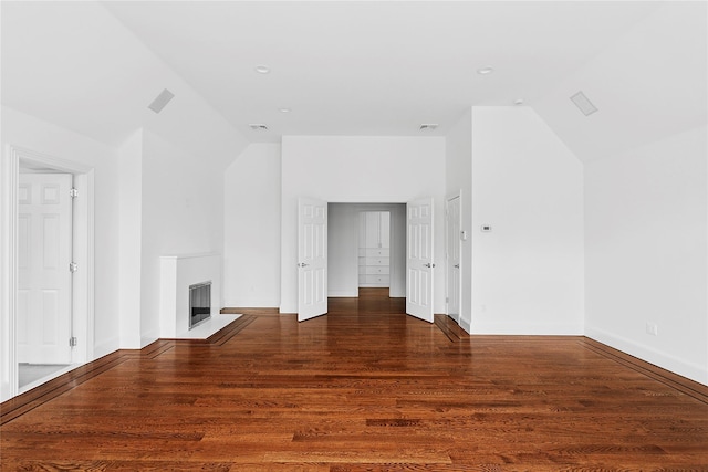 bonus room with a fireplace with flush hearth, baseboards, vaulted ceiling, and wood finished floors