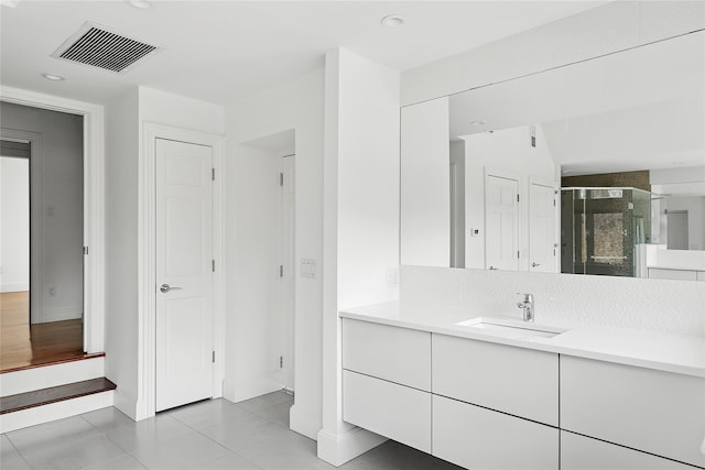 full bathroom featuring a stall shower, a closet, vanity, and visible vents