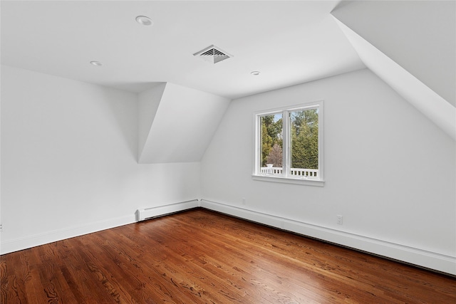 bonus room featuring lofted ceiling, visible vents, baseboard heating, and wood finished floors
