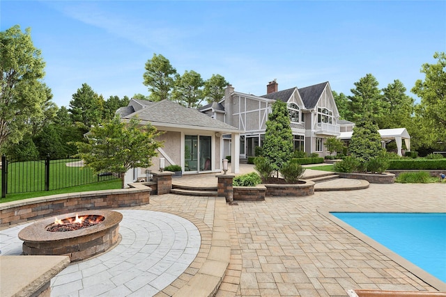 exterior space featuring a fire pit, a patio area, fence, stucco siding, and a fenced in pool