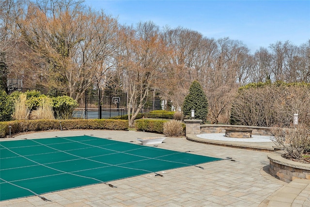 view of swimming pool featuring a diving board, a patio area, an outdoor fire pit, fence, and a fenced in pool
