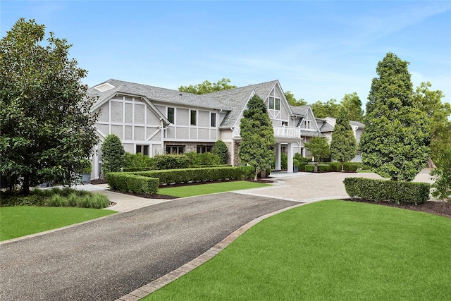 view of front of home with aphalt driveway and a front lawn