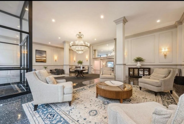 living area with a chandelier, ornate columns, a decorative wall, and crown molding