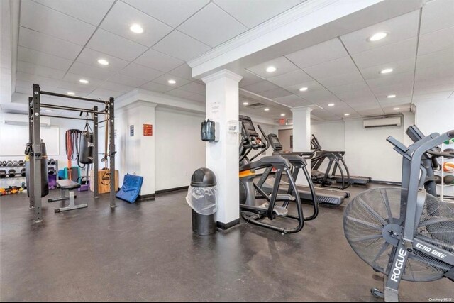 exercise room with decorative columns, a paneled ceiling, recessed lighting, and a wall mounted air conditioner