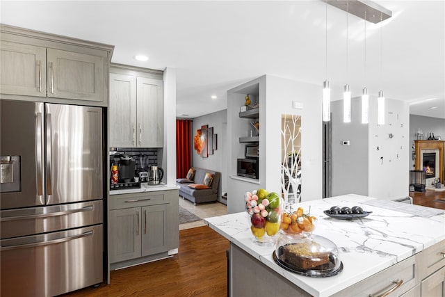 kitchen with gray cabinetry, stainless steel fridge with ice dispenser, dark wood-style flooring, and open floor plan