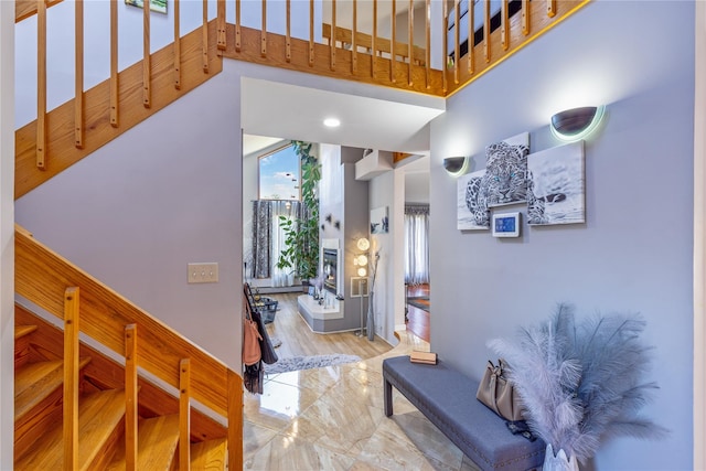 foyer with marble finish floor and a towering ceiling