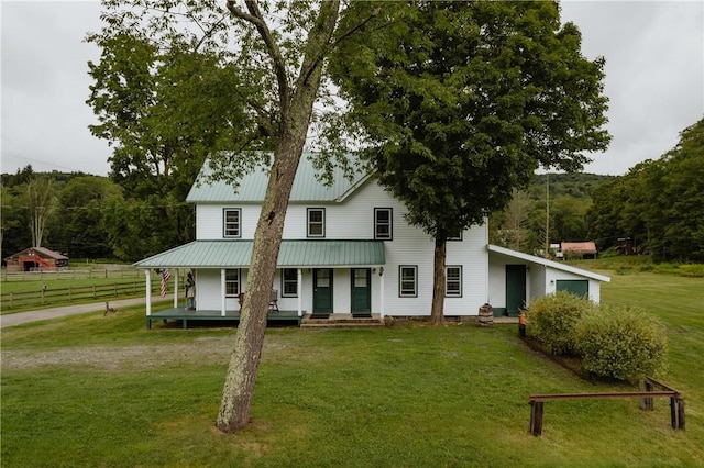 farmhouse with a front yard, a porch, and fence