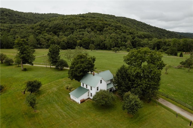 drone / aerial view featuring a rural view, a view of trees, and a mountain view