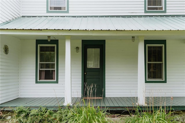 view of exterior entry featuring metal roof and covered porch