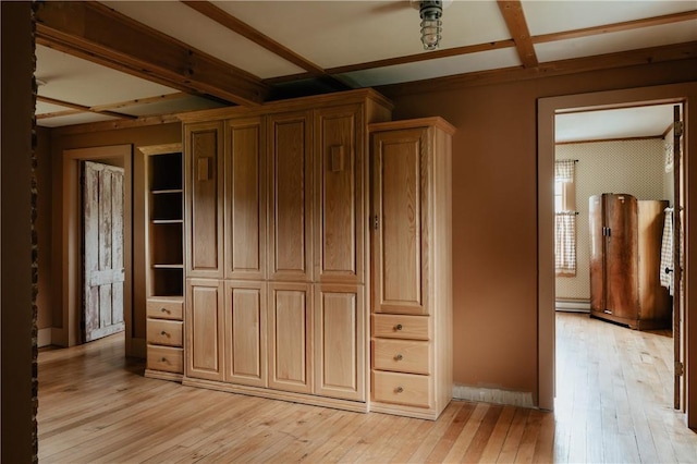 unfurnished bedroom with light wood-style floors, a baseboard heating unit, beamed ceiling, and coffered ceiling