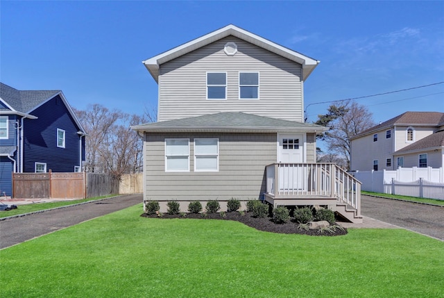 83 Fairview Ave, Islip Terrace, NY 11752 - view of front facade featuring a shingled roof, fence, and a front lawn