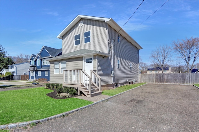 83 Fairview Ave, Islip Terrace, NY 11752 - view of front facade featuring driveway, fence, and a front lawn