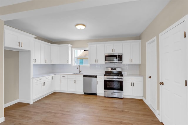 83 Fairview Ave, Islip Terrace, NY 11752 - kitchen with white cabinets, a sink, light countertops, appliances with stainless steel finishes, and backsplash