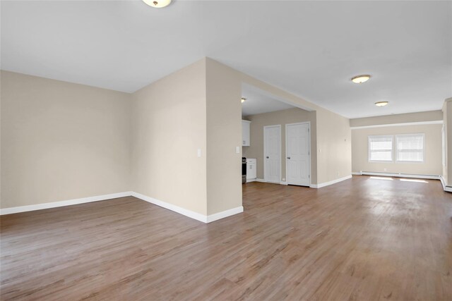 83 Fairview Ave, Islip Terrace, NY 11752 - empty room featuring a baseboard radiator, light wood finished floors, and baseboards
