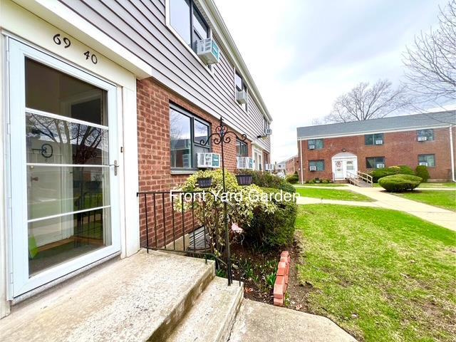 69-40 218th St Duplex, Unit Duplex, Oakland Gardens, NY 11364 - view of side of home featuring brick siding, a yard, and cooling unit