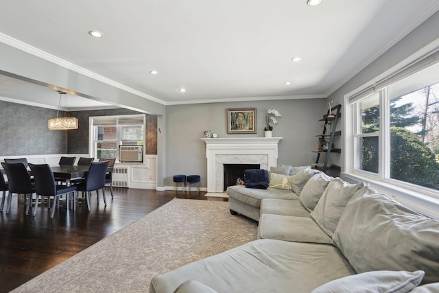 living area with recessed lighting, radiator, a high end fireplace, wood finished floors, and cooling unit