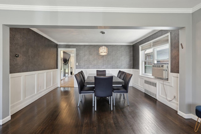 dining room featuring dark wood finished floors, radiator heating unit, a wainscoted wall, and cooling unit