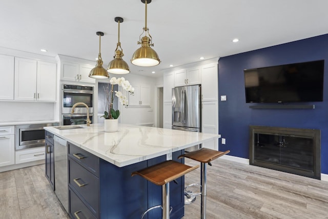 kitchen with white cabinets, light wood-style flooring, recessed lighting, light stone counters, and appliances with stainless steel finishes