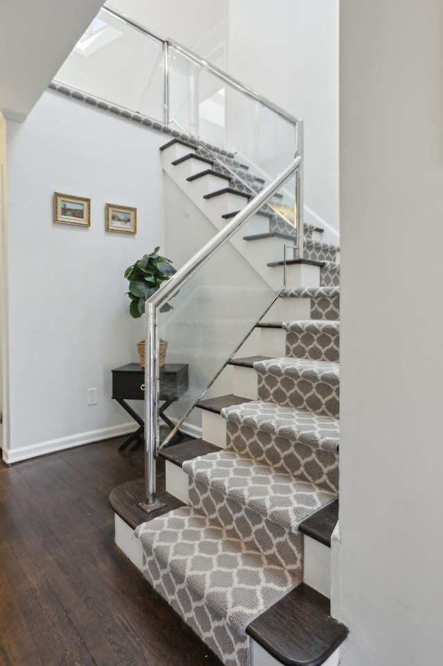 staircase with wood finished floors and baseboards
