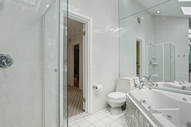 bathroom featuring tile patterned floors, a jetted tub, visible vents, a skylight, and a stall shower