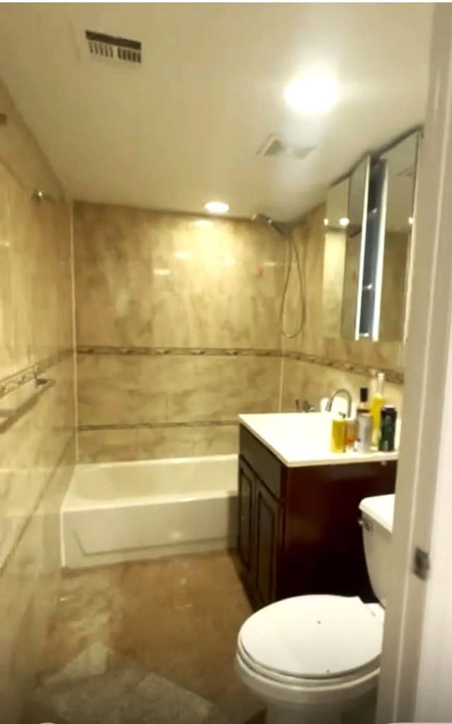104-27 38th Ave Unit 1B, Corona, NY 11368 - bathroom with visible vents, toilet, tile walls,  shower combination, and vanity