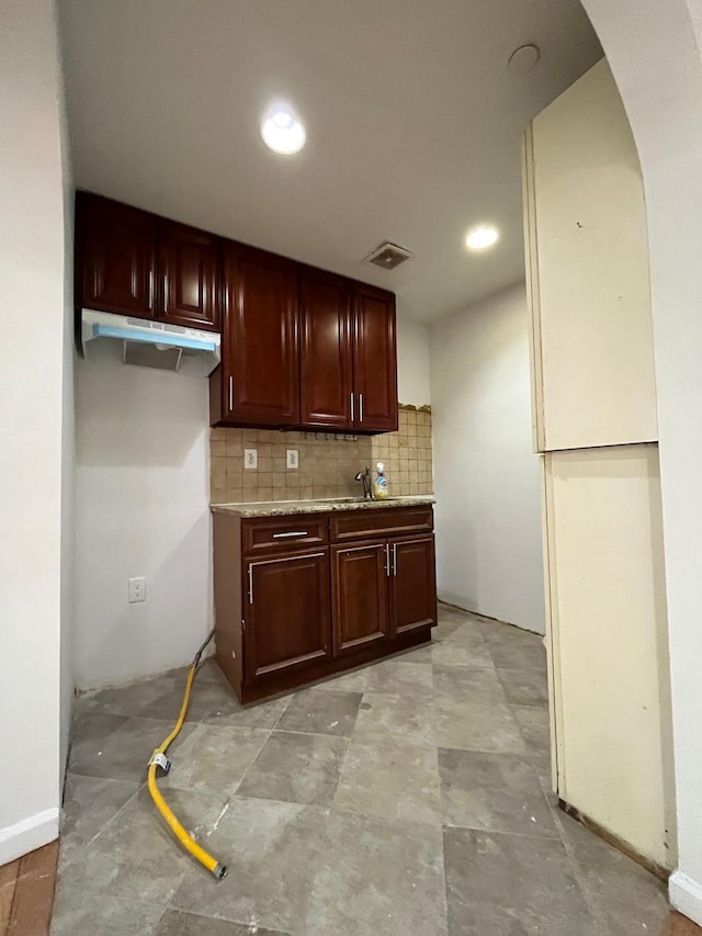 104-27 38th Ave Unit 1B, Corona, NY 11368 - kitchen featuring tasteful backsplash, visible vents, arched walkways, under cabinet range hood, and reddish brown cabinets