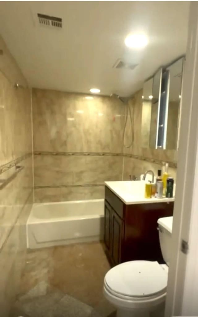 104-27 38th Ave Unit 1B, Corona, NY 11368 - full bath featuring visible vents, toilet, tile walls, vanity, and shower / bathtub combination