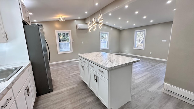 734 Cooley Rd, Parksville, NY 12768 - kitchen with a wall mounted AC, freestanding refrigerator, a center island, light wood-type flooring, and white cabinetry