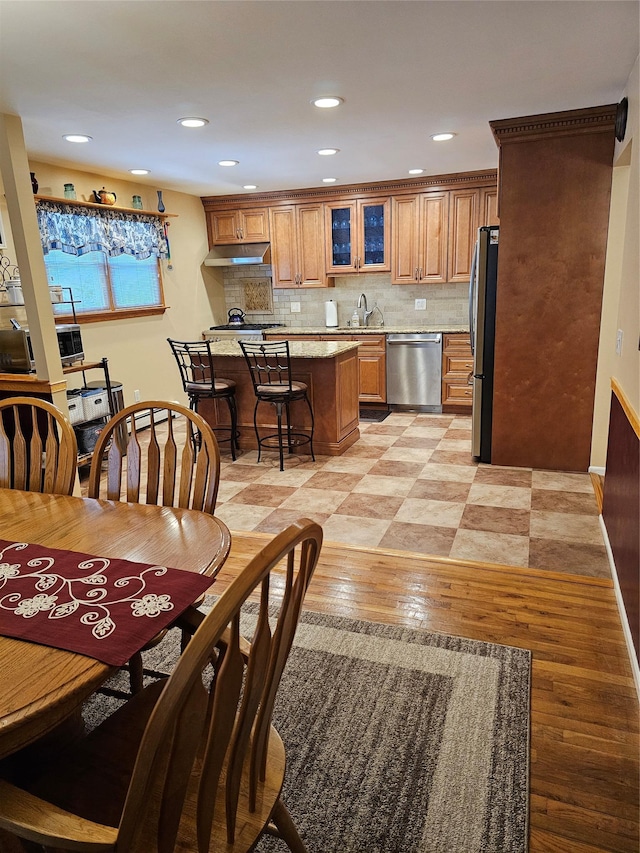 dining area featuring baseboards, light wood finished floors, and recessed lighting