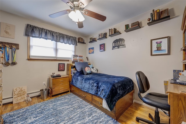 bedroom featuring a baseboard radiator, a ceiling fan, and wood finished floors