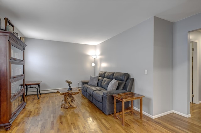 living area featuring light wood finished floors, baseboard heating, and baseboards