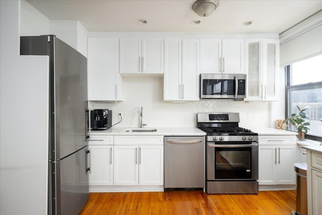 710 Riverside Dr Unit 6B, New York Manhattan, NY 10031 - kitchen featuring appliances with stainless steel finishes, light countertops, backsplash, a sink, and white cabinetry