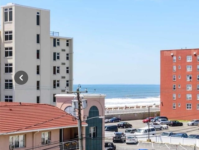 view of property with a water view and uncovered parking