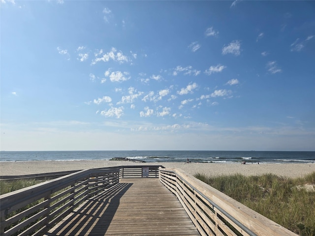 surrounding community featuring a water view and a beach view