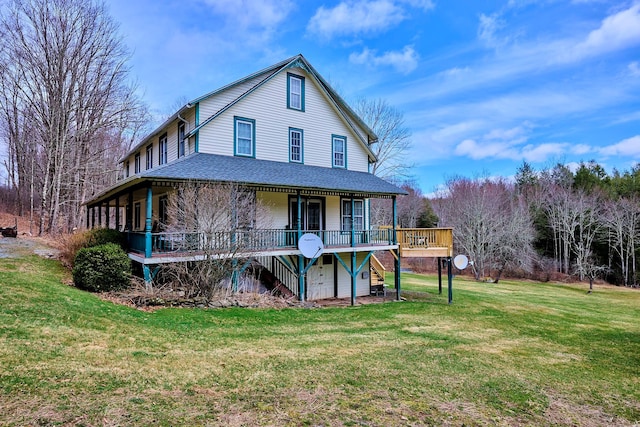 back of property with roof with shingles, a deck, a yard, and stairway