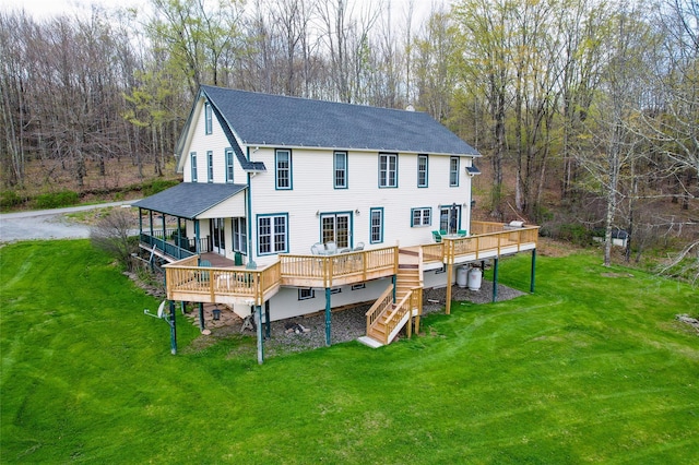 rear view of house featuring a yard, a shingled roof, stairs, and a wooden deck